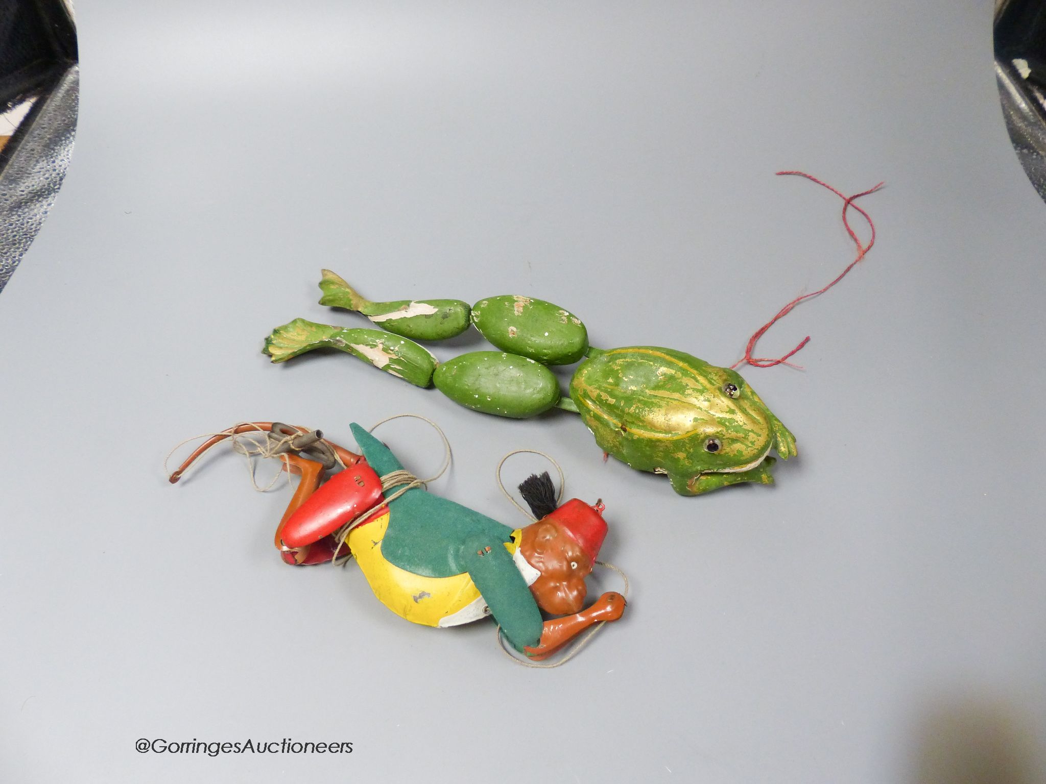 A Lehman tinplate EPL385 climbing monkey, with green felt coat, yellow waistcoat and red fez, together with a clockwork carved wood frog (2)